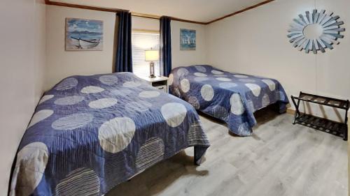 1 Schlafzimmer mit 2 Betten und einem Wandspiegel in der Unterkunft Island Club #95 in Put-in-Bay