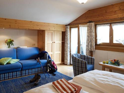 a bedroom with a blue couch and a bed at Landhaus Kaiserblick in Ellmau