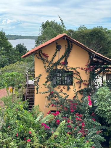 a house with flowers on the side of it at Vila Ypáwa 150 m centro 30 m praia lago verde in Alter do Chao