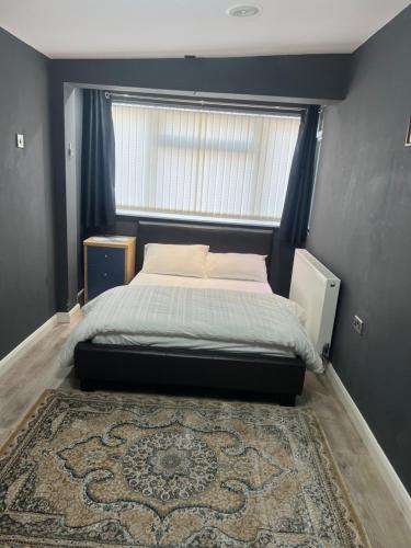 a bedroom with a bed with a window and a rug at Rooms in Surrey in Laleham