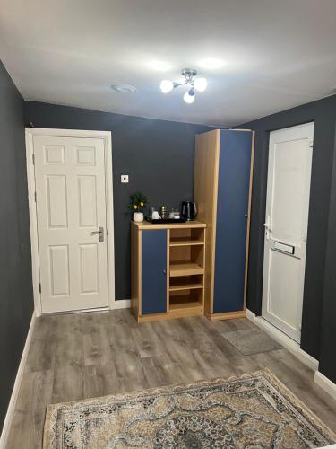 a room with blue walls and a door and a shelf at Rooms in Surrey in Laleham