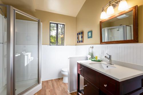 W łazience znajduje się toaleta, umywalka i prysznic. w obiekcie Hot Tub, Private Lake, & Huge Deck at Chalet Cabin w mieście Berkeley Springs