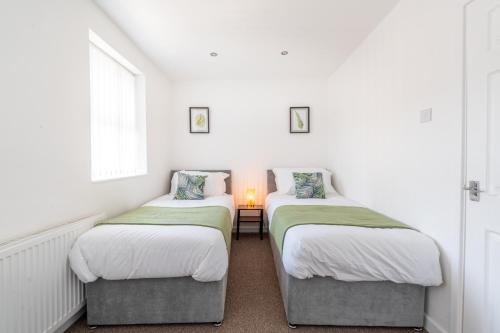 2 camas individuais num quarto com uma janela em Home from Home - 5 mins from town! em Liverpool