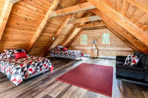 Cette chambre mansardée comprend deux lits et un canapé. dans l'établissement Amazing Views, Hot Tub, Huge Deck at Chalet Cabin, à Great Cacapon