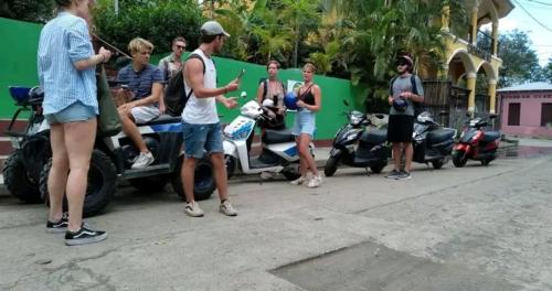 a group of people standing next to motorcycles on a street at Cocos Hostel in Moyogalpa