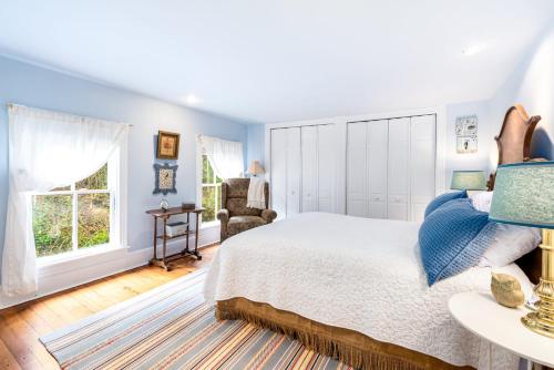 Enchanting Cottage, Center of Historic Downtown! في هاربرز فيري: غرفة نوم بجدران زرقاء وسرير كبير