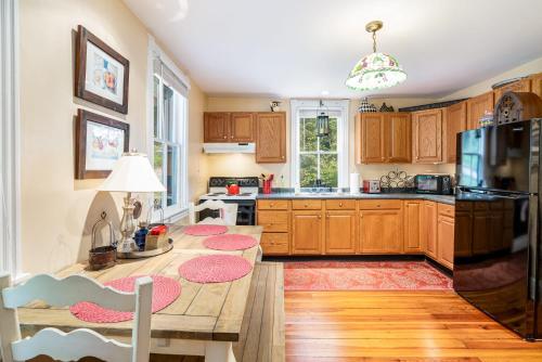 a kitchen with wooden cabinets and a table with red mats at Enchanting Cottage, walk to Downtown Harpers Ferry in Harpers Ferry