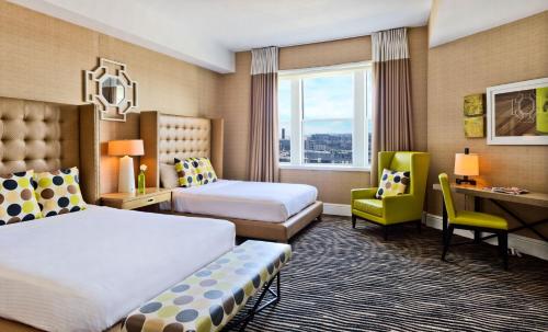 a hotel room with two beds and a desk at Berkeley Oceanfront Hotel in Asbury Park