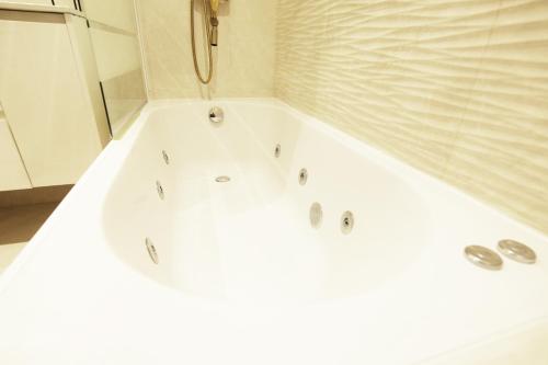 a white bath tub in a bathroom at Paradise Luxurious apartment, 3 double rooms for 6 guests, 4 beds, terrace, jacuzzi, free parking, new in Donostia-San Sebastián