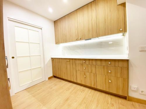 an empty kitchen with wooden cabinets and a window at Paradise Luxurious apartment, 3 double rooms for 6 guests, 4 beds, terrace, jacuzzi, free parking, new in Donostia-San Sebastián