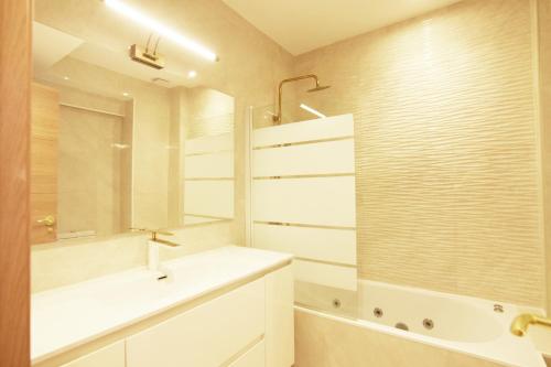 a white bathroom with a sink and a shower at Paradise Luxurious apartment, 3 double rooms for 6 guests, 4 beds, terrace, jacuzzi, free parking, new in Donostia-San Sebastián