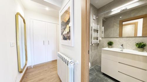 a bathroom with a white sink and a mirror at Paradise Luxurious flat, free parking, 3 double rooms, terrace, jacuzzi, fully renovated in San Sebastián