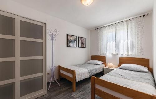 een slaapkamer met 2 bedden en een raam bij Apartments with a parking space Valbandon, Fazana - 7227 in Fažana