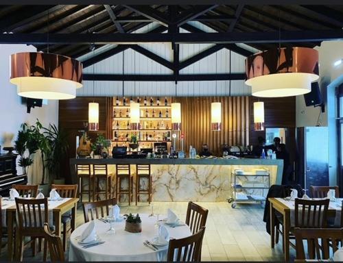a restaurant with tables and chairs and a bar at Salero Guest House in Loures