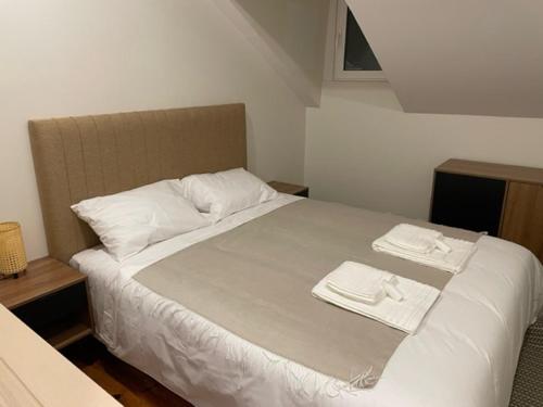 a bedroom with a bed with two white towels on it at Salero Guest House in Loures