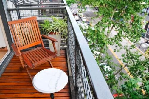 a wooden deck with a chair and a table on a balcony at Corrientes y Riobamba in Buenos Aires