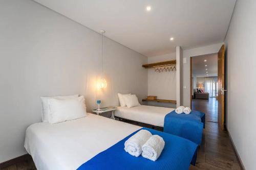 ein Schlafzimmer mit 2 Betten und einem blauen Sofa in der Unterkunft Beach Retreat in Torres Vedras
