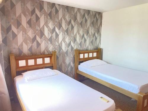 Zimmer mit 2 Betten und einer Wand in der Unterkunft Sweet Home RIOHACHA in Ríohacha