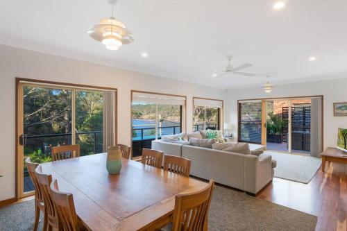 a living room with a table and a couch at Gillmith - At the Pambula River Mouth in Pambula Beach