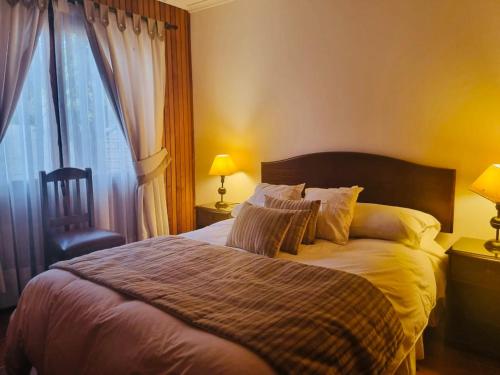 a bedroom with a bed and a window and a chair at Pueblo Andaluz Olmué in Olmué