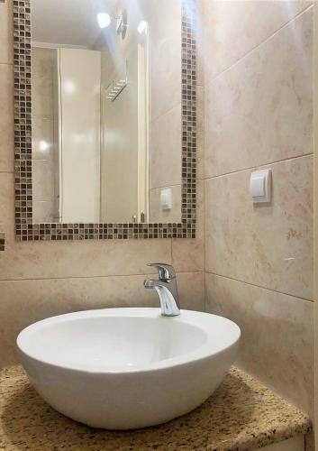 a bathroom with a white sink and a mirror at BAJKA in Čačak