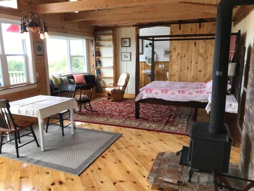 a living room with a bed and a wood stove at MareGold Centre - Juniper Cabin and Rose Cabin in Victoria Beach 