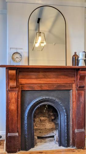 a fireplace with a mirror on top of it at Roseland Cottage - CBD Heritage in Orange