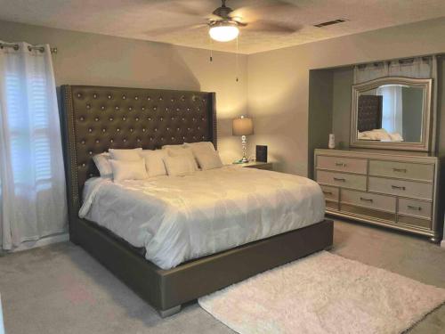 a bedroom with a bed and a dresser and a mirror at Renovated 3bedroom 2.5bath 2 story house w/ garage in Lawrenceville