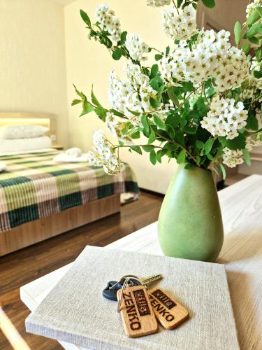 a table with two keys and a vase with flowers at Villa ZENKO in Lviv