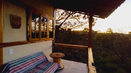 a porch of a house with a bench and a window at Sitio Boa Fé - 300m das cachoeiras Moinho e Salomão in Carrancas