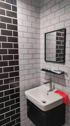 a bathroom with a sink and a mirror at De sepakat cottage private pool in Kuantan
