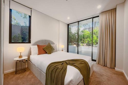 a bedroom with a large bed and large windows at Le Soleil The Sun-Inspired Luxury Apartment in Sydney