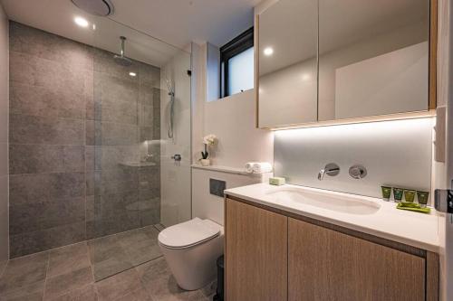 a bathroom with a toilet and a sink and a shower at Le Soleil The Sun-Inspired Luxury Apartment in Sydney