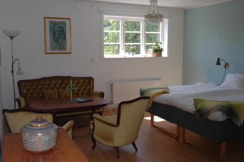 um quarto com uma cama, uma mesa e uma cadeira em Sundsmåla Landsbygdshotell em Brokind