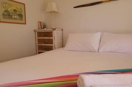 a bedroom with a white bed and a dresser at The Dunes - King Studio - 50m from Scamander Beach in Scamander