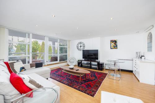 a living room with a white couch and a table at Canary Wharf Apartments By Austin David in London