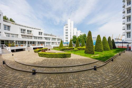 a park with trees and bushes in front of a building at Canary Wharf Apartments By Austin David in London