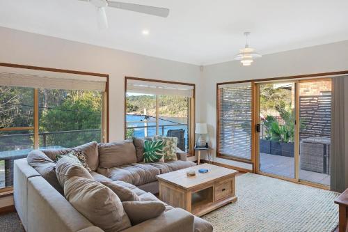 a living room with a couch and a table at Gillmith - At the Pambula River Mouth in Pambula Beach