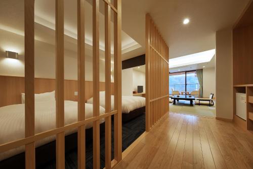 日光鬼怒川日光酒店(Hotel Sunshine Kinugawa)的房间里有一张床和一张书桌的卧室
