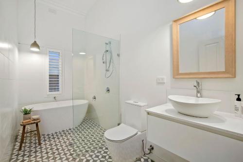 a bathroom with a tub and a sink and a toilet at Victorian Coastal in Portarlington