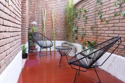 un patio con 2 sillas y una pared de ladrillo en Alojamiento Ideal en Ciudad de Mendoza - Amplio y bien ubicado en Mendoza