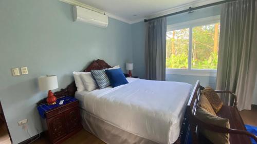 Un dormitorio con una gran cama blanca y una ventana en CASA DEL LAGO, en Cachí