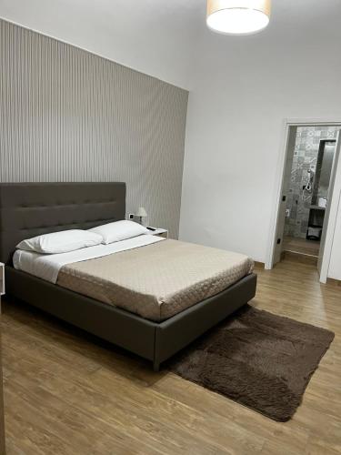 een slaapkamer met een groot bed met een bruin hoofdeinde bij B&b Vesuviano in Ercolano