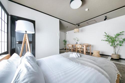 Un dormitorio con una cama blanca y una mesa. en ぷふか芝公園　(Pufuka Shibakoen), en Tokio