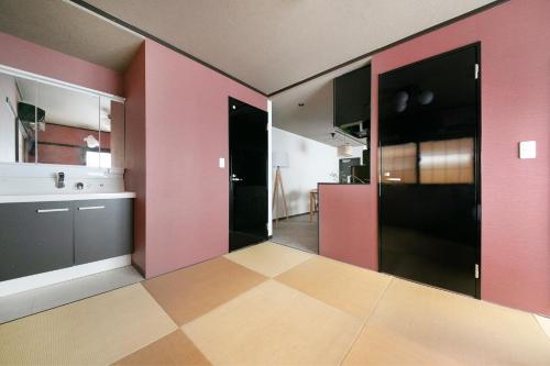 Una cocina con paredes rosas y suelo a cuadros. en ぷふか芝公園　(Pufuka Shibakoen), en Tokio