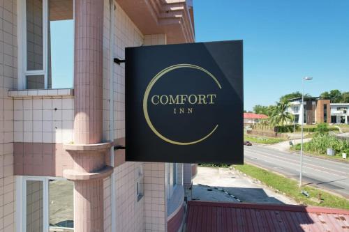 a sign for a hotel on the side of a building at Comfort Inn in Kampong Selayun