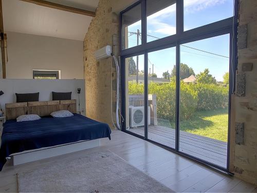een slaapkamer met een bed en een grote glazen schuifdeur bij Inviting holiday home in Gourdon with terrace in Gourdon-en-quercy
