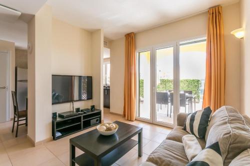 ein Wohnzimmer mit einem Sofa und einem TV in der Unterkunft Ferienhaus für 4 Personen ca 105 m in Sa Rapita, Mallorca Südküste von Mallorca - a88430 in Sa Ràpita
