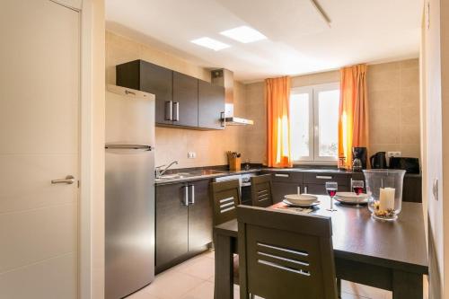 eine Küche mit einem Kühlschrank und einem Tisch mit Gläsern Wein in der Unterkunft Ferienhaus für 4 Personen ca 105 m in Sa Rapita, Mallorca Südküste von Mallorca - a88430 in Sa Ràpita