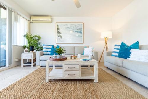 a living room with a couch and a table at Fleetwood 4 Air conditioned unit with water views in Shoal Bay